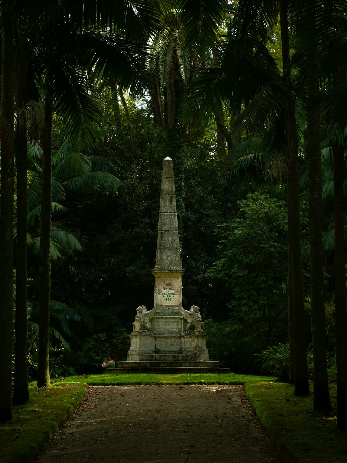 Monument funéraire de pierre entouré de verdure, alliance de mémoire et de nature